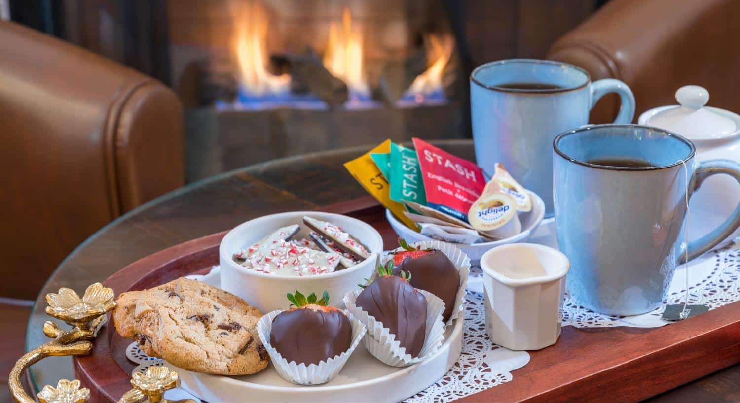 tray with refreshments of chocolate strawberries, chocolate chip cookie, peppermint bar, tea mugs with cream and sugar dispensers