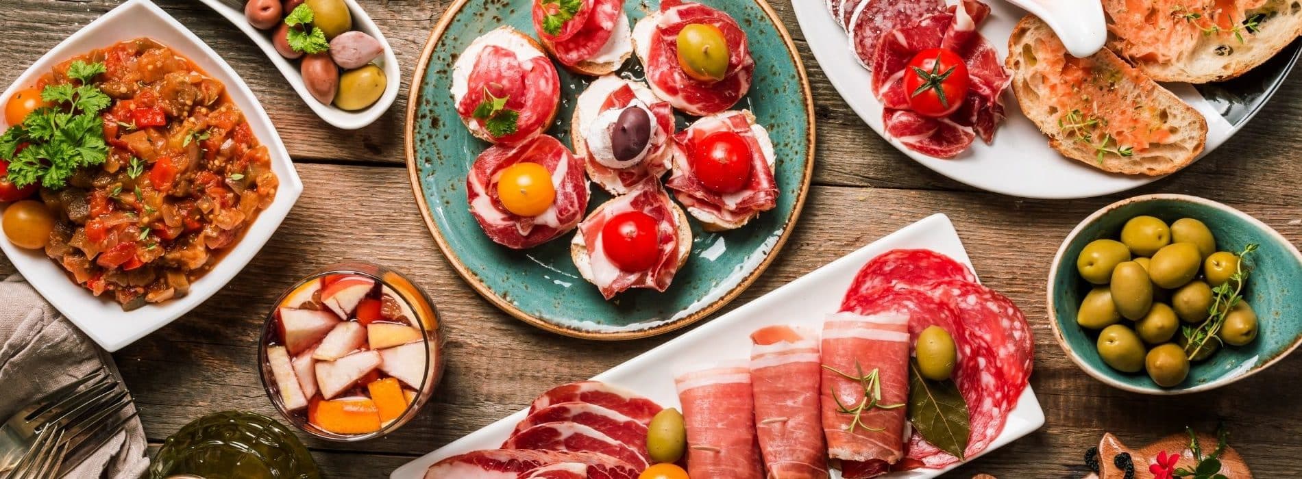 Table full of plates filled with Spanish-style food