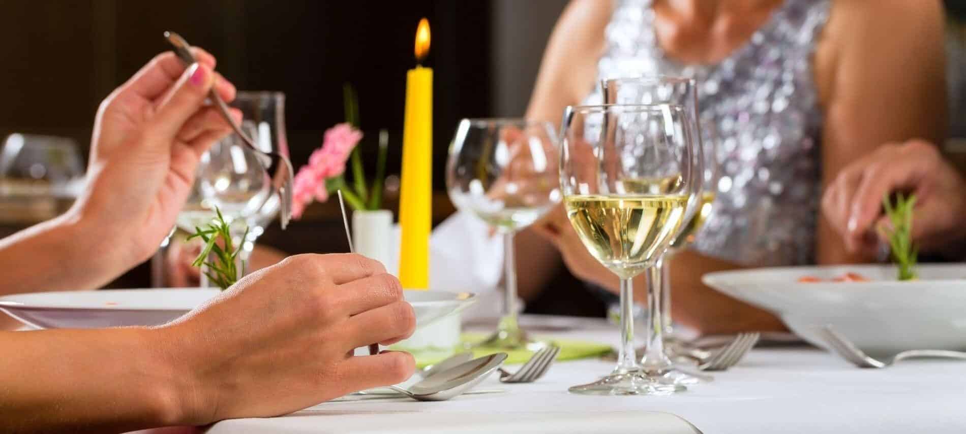 Hands of a couple reaching across a candlelit dining table