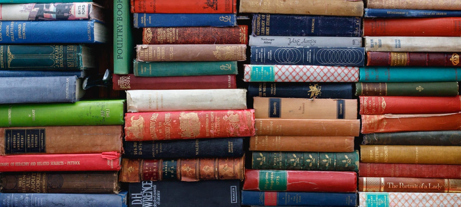 Book shelf full of stacks of books.