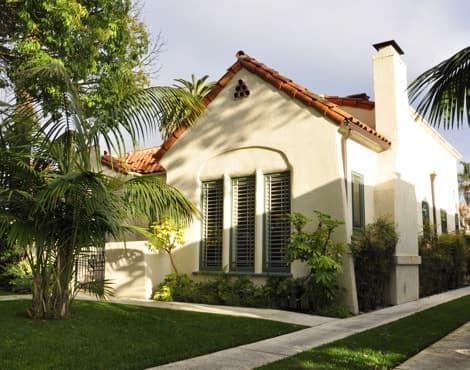 Exterior view of casitas with ivory stucco, red tile roof, green grass and palm trees