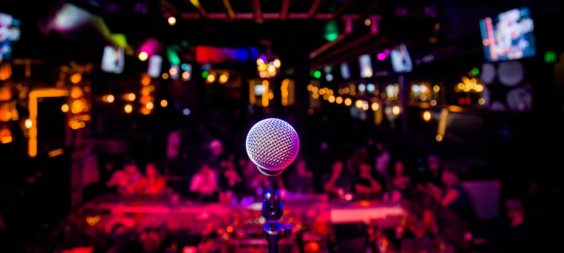 A single microphone with colorful lights in a darker background