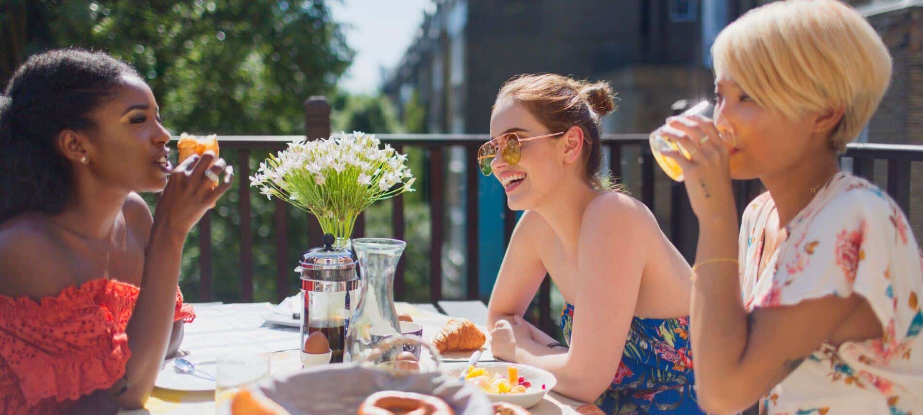 women talking, laughing, and having brunch together
