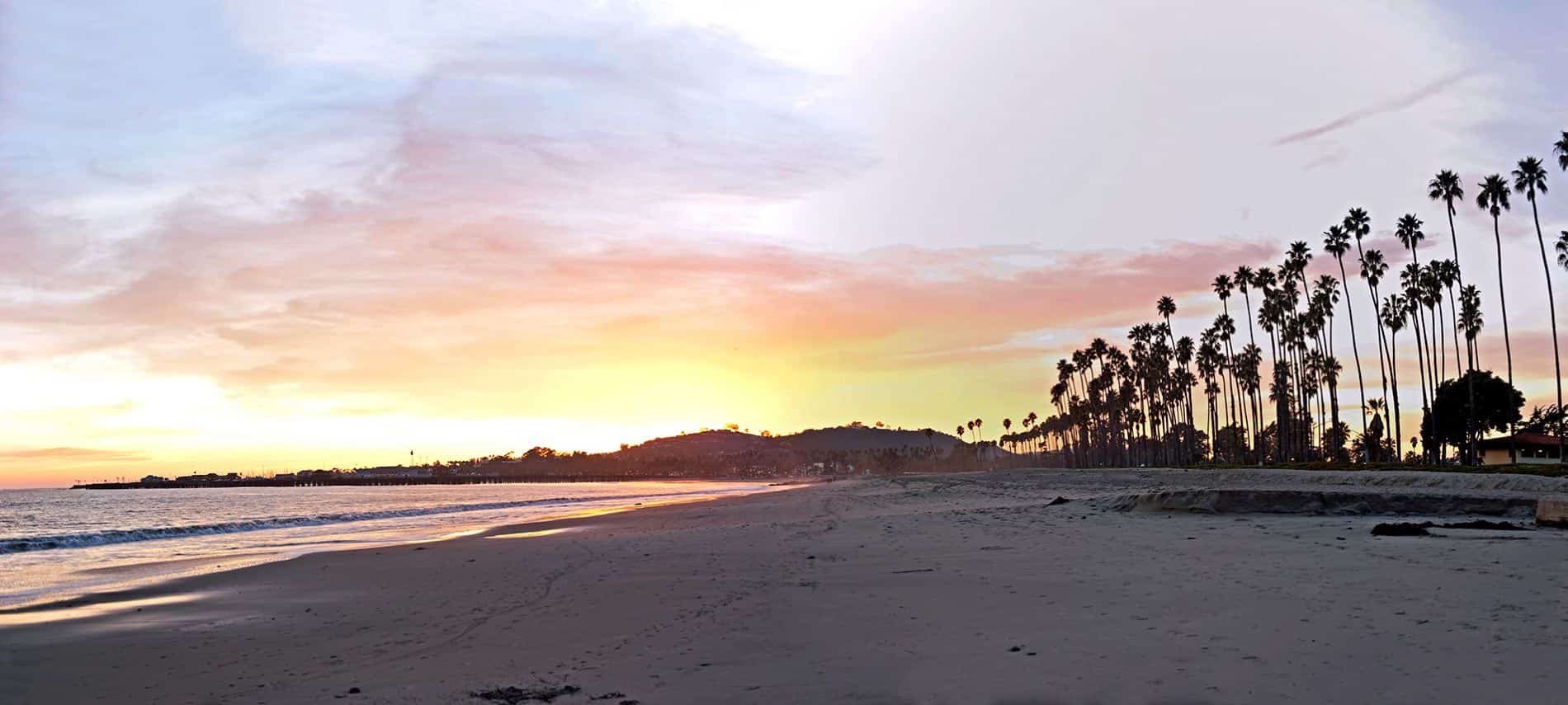 Beach at sunset with yellow and pink skies