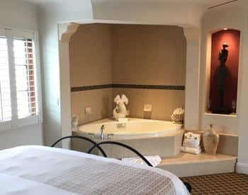 San Nicolas guest room with semi-enclosed corner spa and lit niche with a sculpture