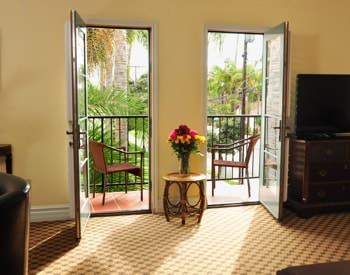 Superior King guest room with two glass doors to the balcony, carpeting, and flat screen TV