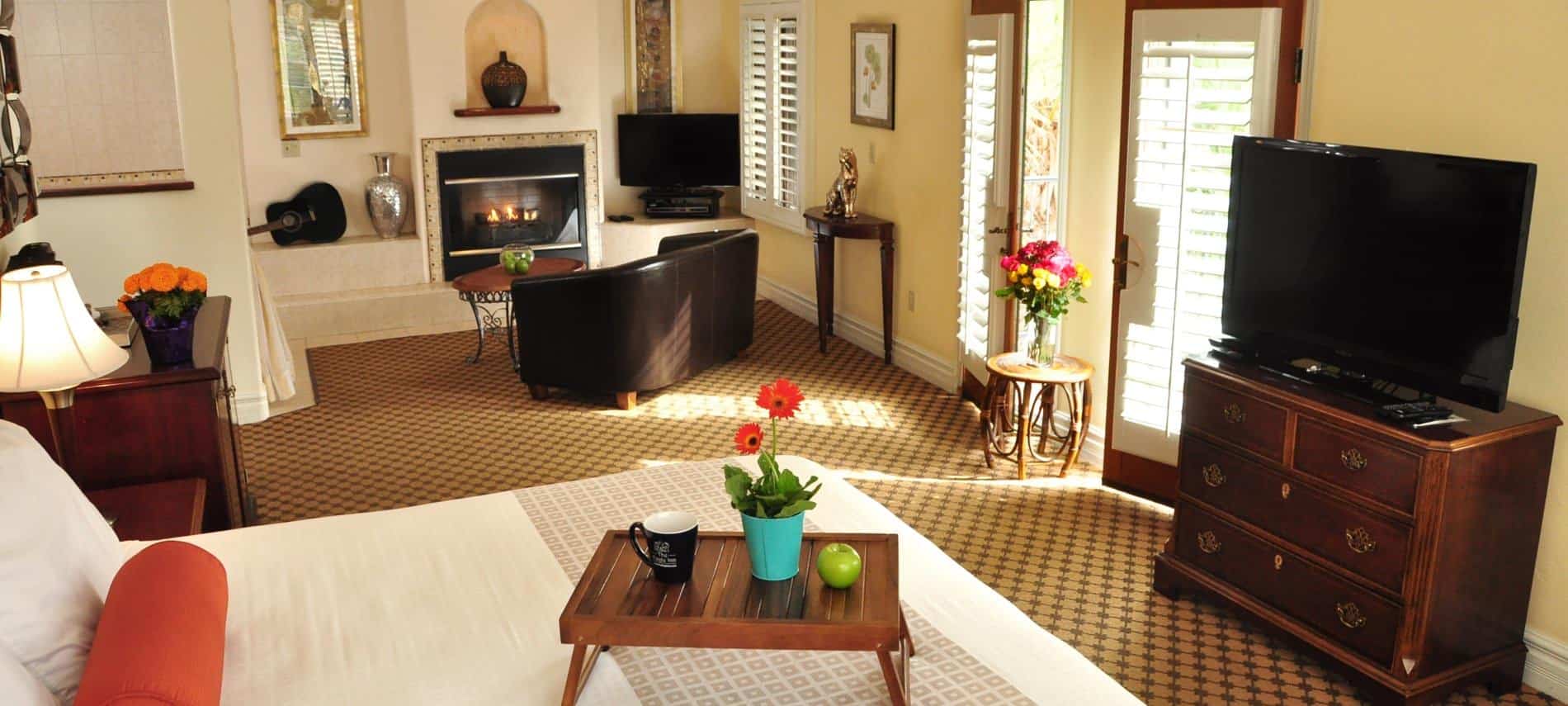 Spacious guest suite with fireplace, TV. desk with chair, niche for art and natural light