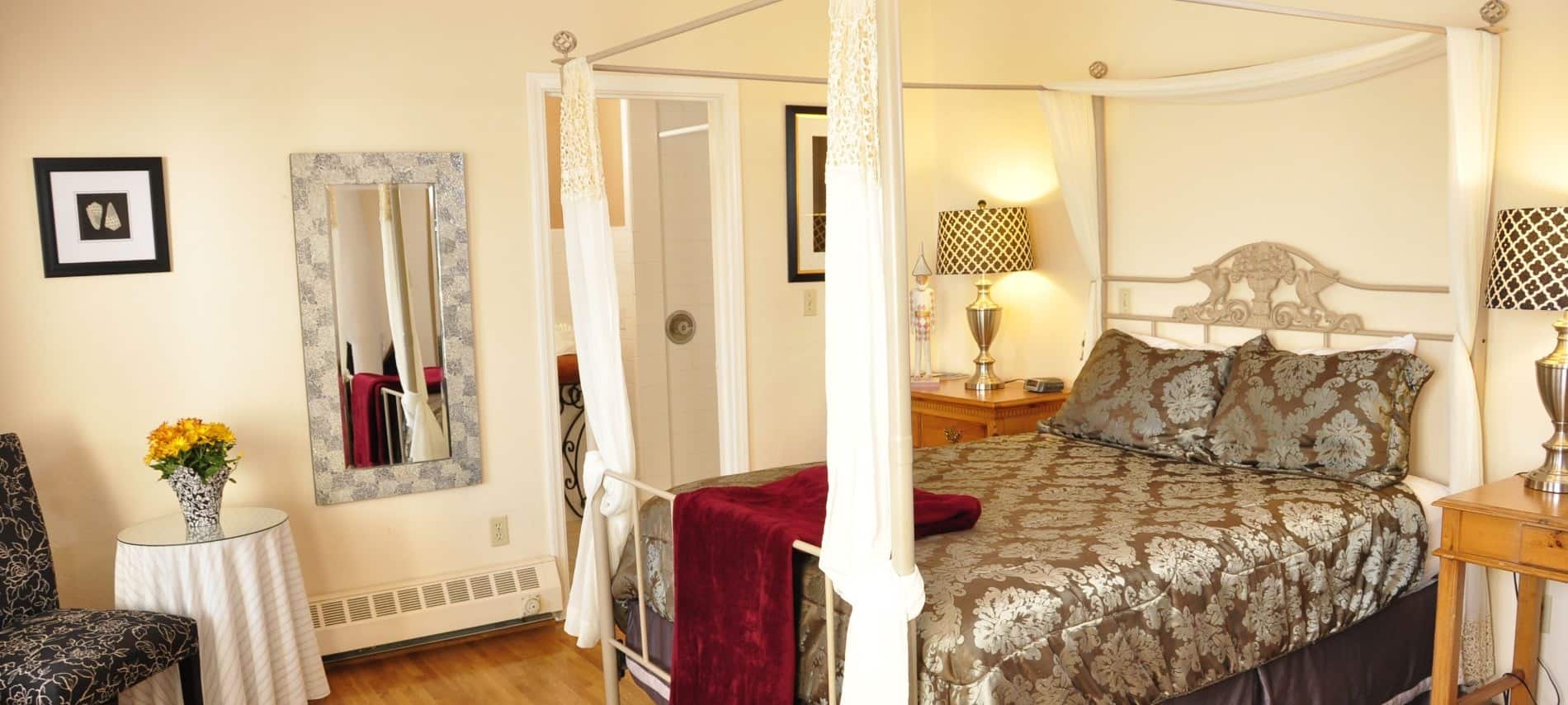Queen balcony guest room with fireplace, television, and wood floors