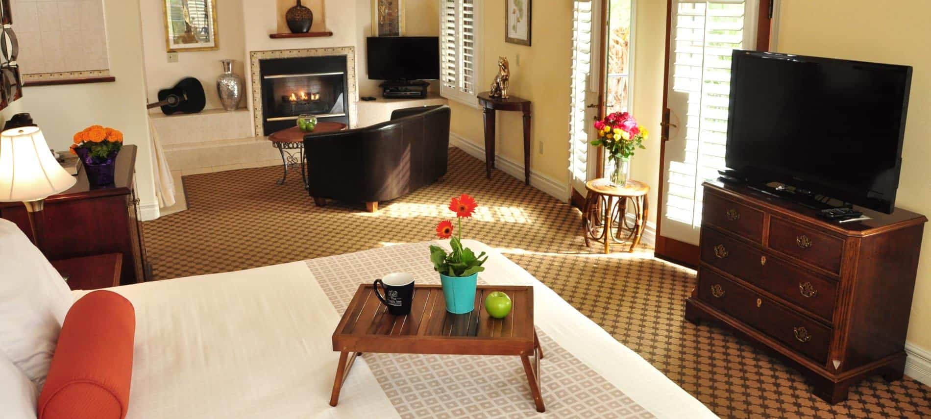 Superior King guest room with two glass doors to the balcony, carpeting, and flat screen TV