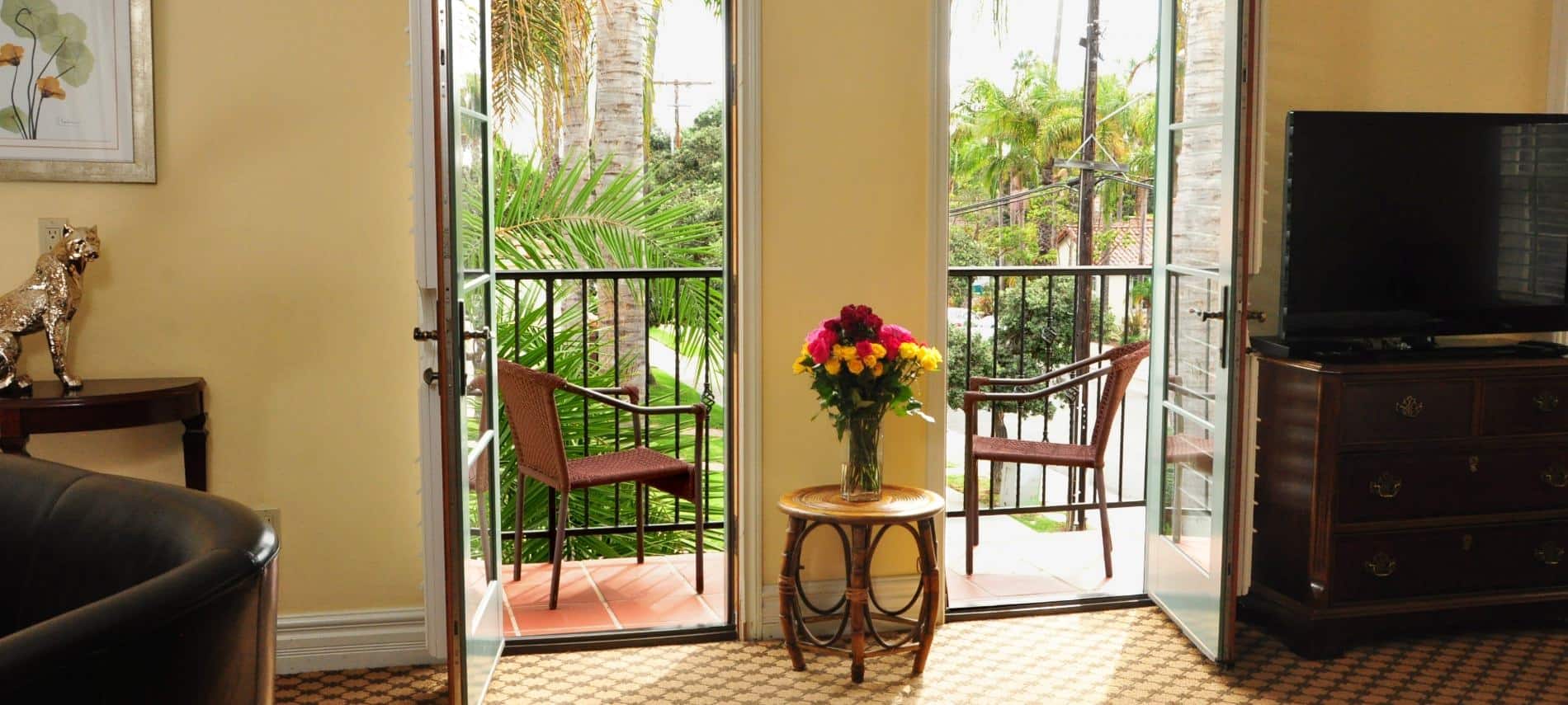 Superior King guest room with two glass doors to the balcony, carpeting, and flat screen TV