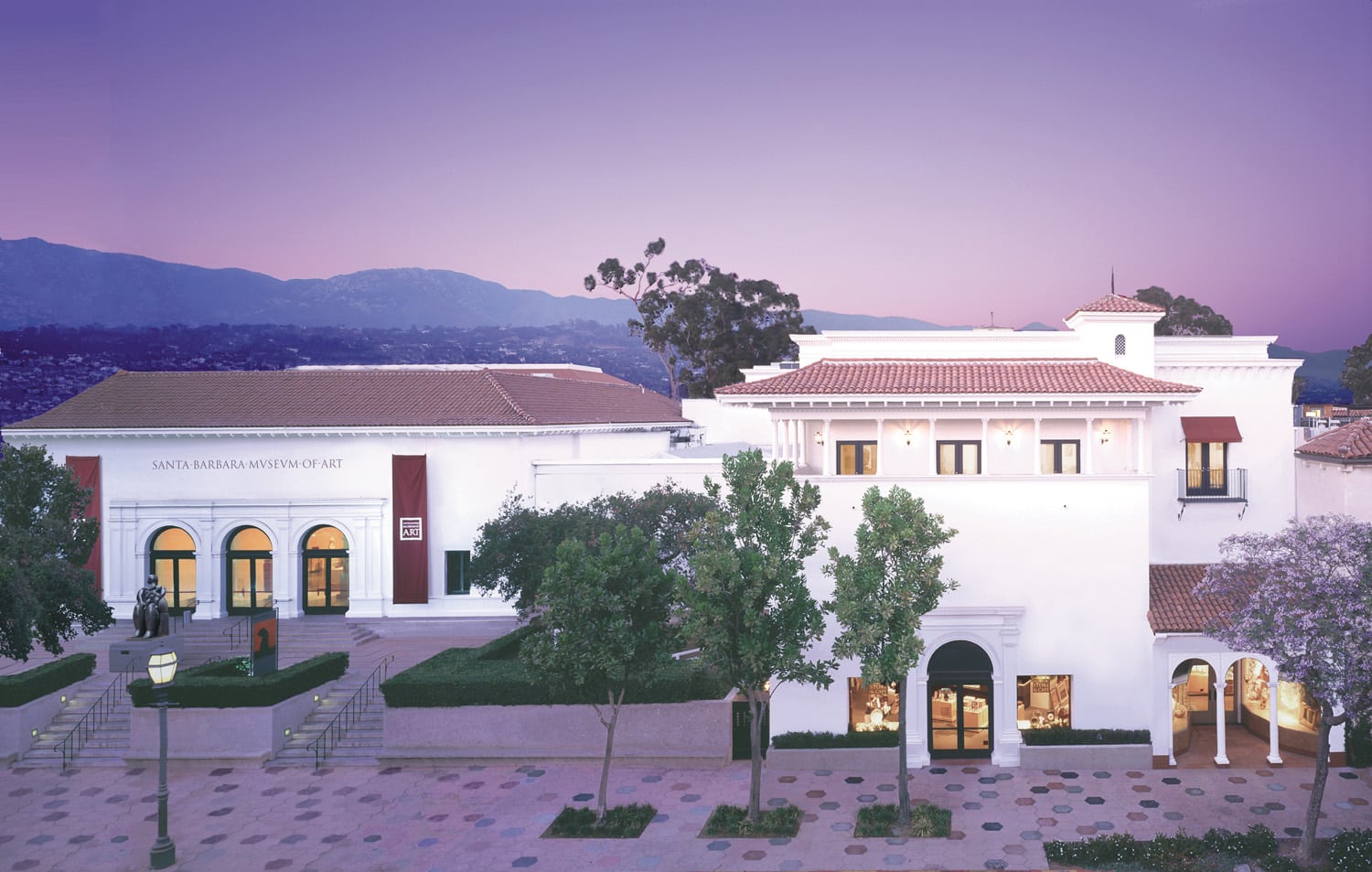 Exterior of Santa Barbara Museum of Art amidst purple skies and distant mountains