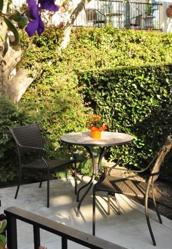 Anacapa guest patio with round table and two chairs surrounded by green shrubs