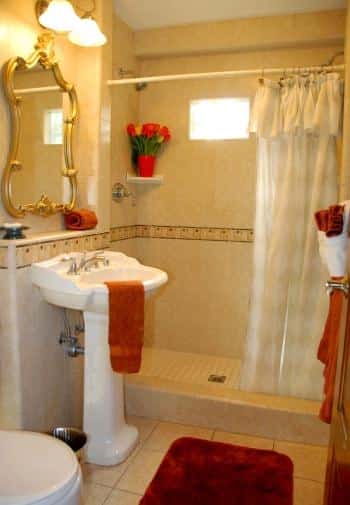 King bathroom with white pedestal sink and tiled shower