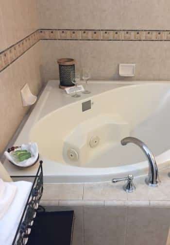 Deluxe king guest room with whirlpool tub surrounded by tile