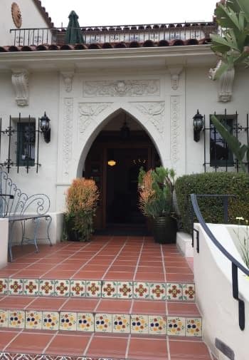 Front entrance with tile flooring and green shrubs