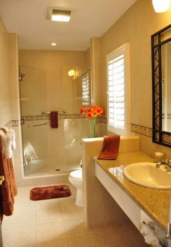 Santa Cruz guest bath with window, tiled shower with glass door, long vanity with sink and wall mirror